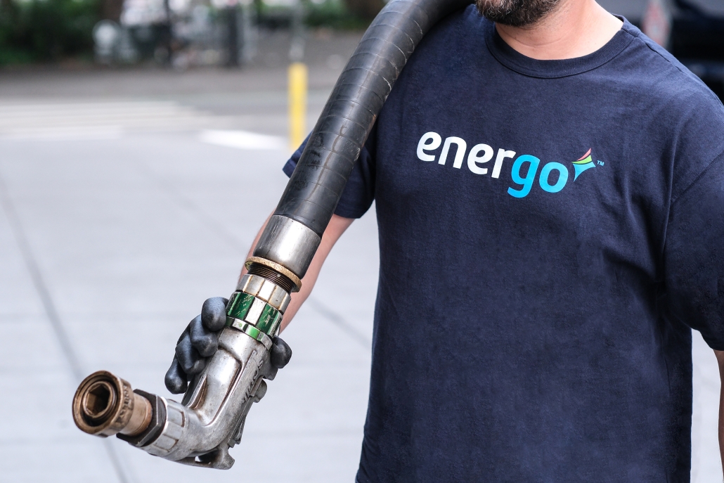 Fuel Employee with Hose Energo employee wearing gloves with hose over shoulder