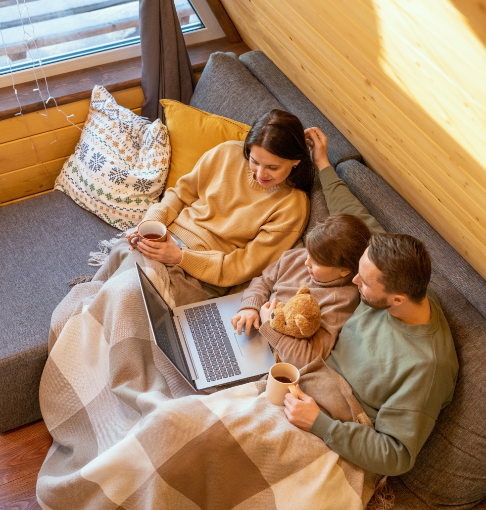Young family relaxing on the sofa at home (cropped)