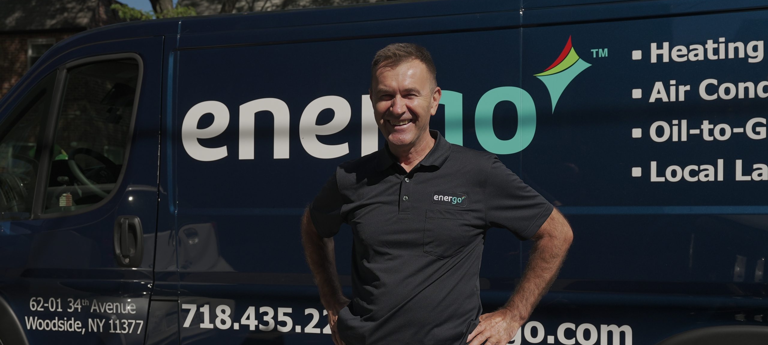 Energo staff member smiling next to company vehicle
