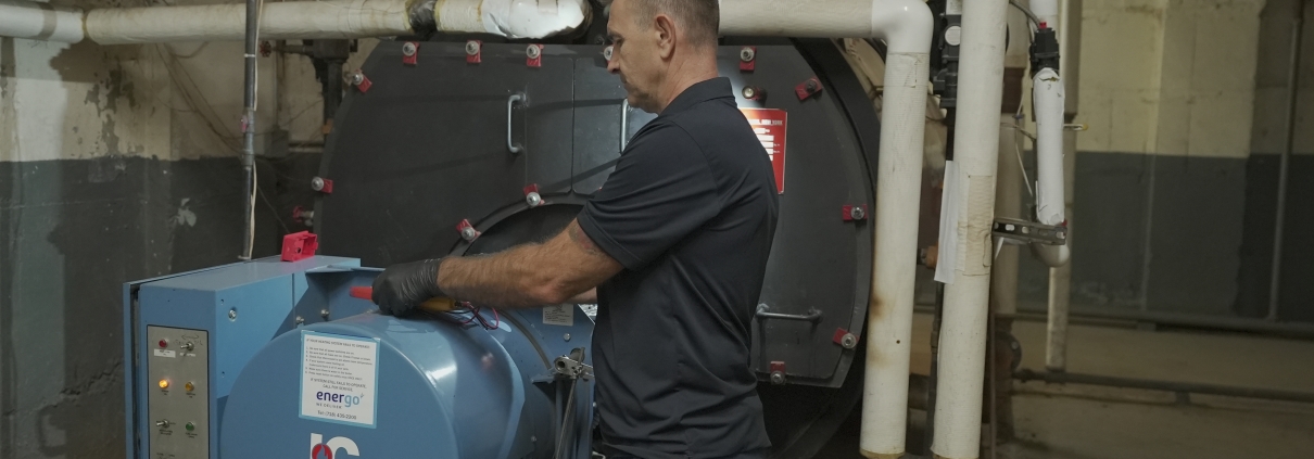 Energo technician performing Local Law 62 boiler inspection in NYC building basement