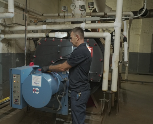 Energo technician performing Local Law 62 boiler inspection in NYC building basement