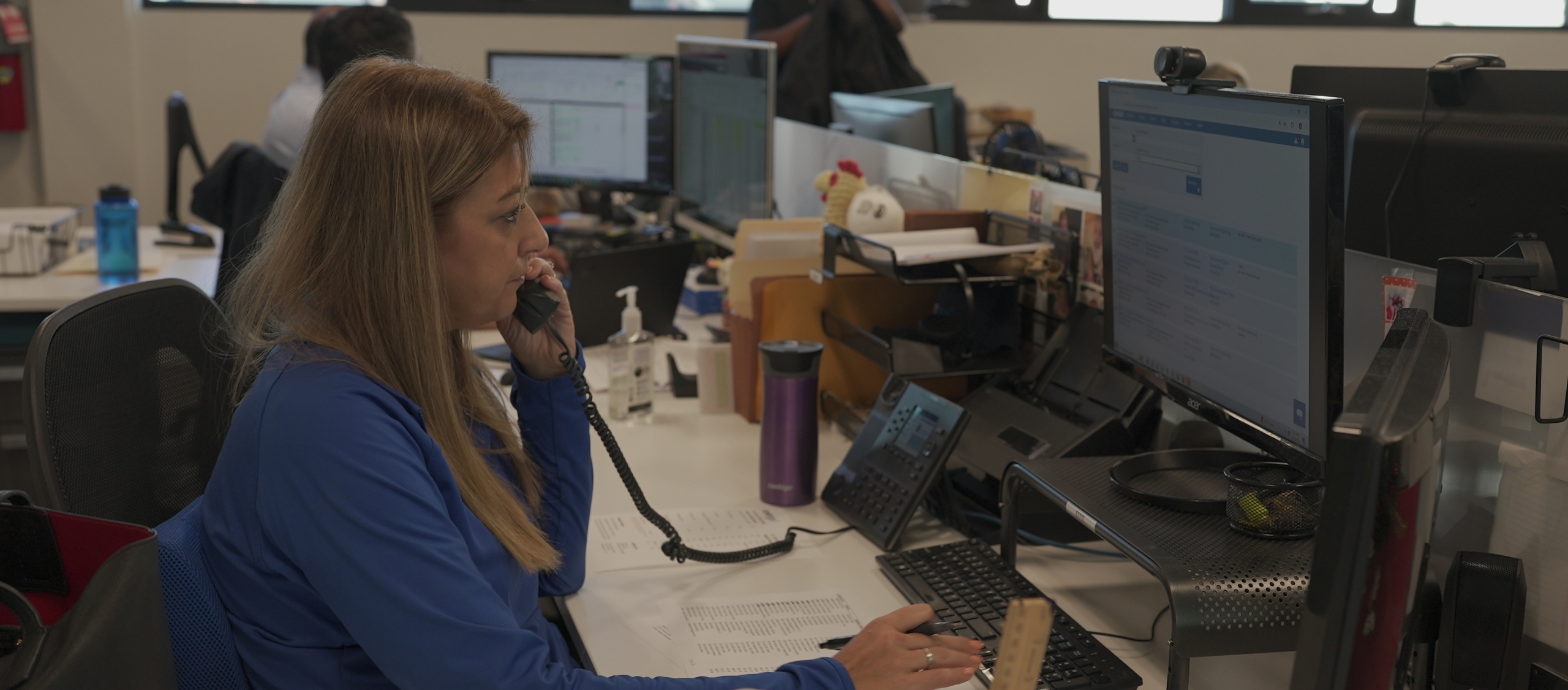 Energo office staff member on phone while working at desk with computer