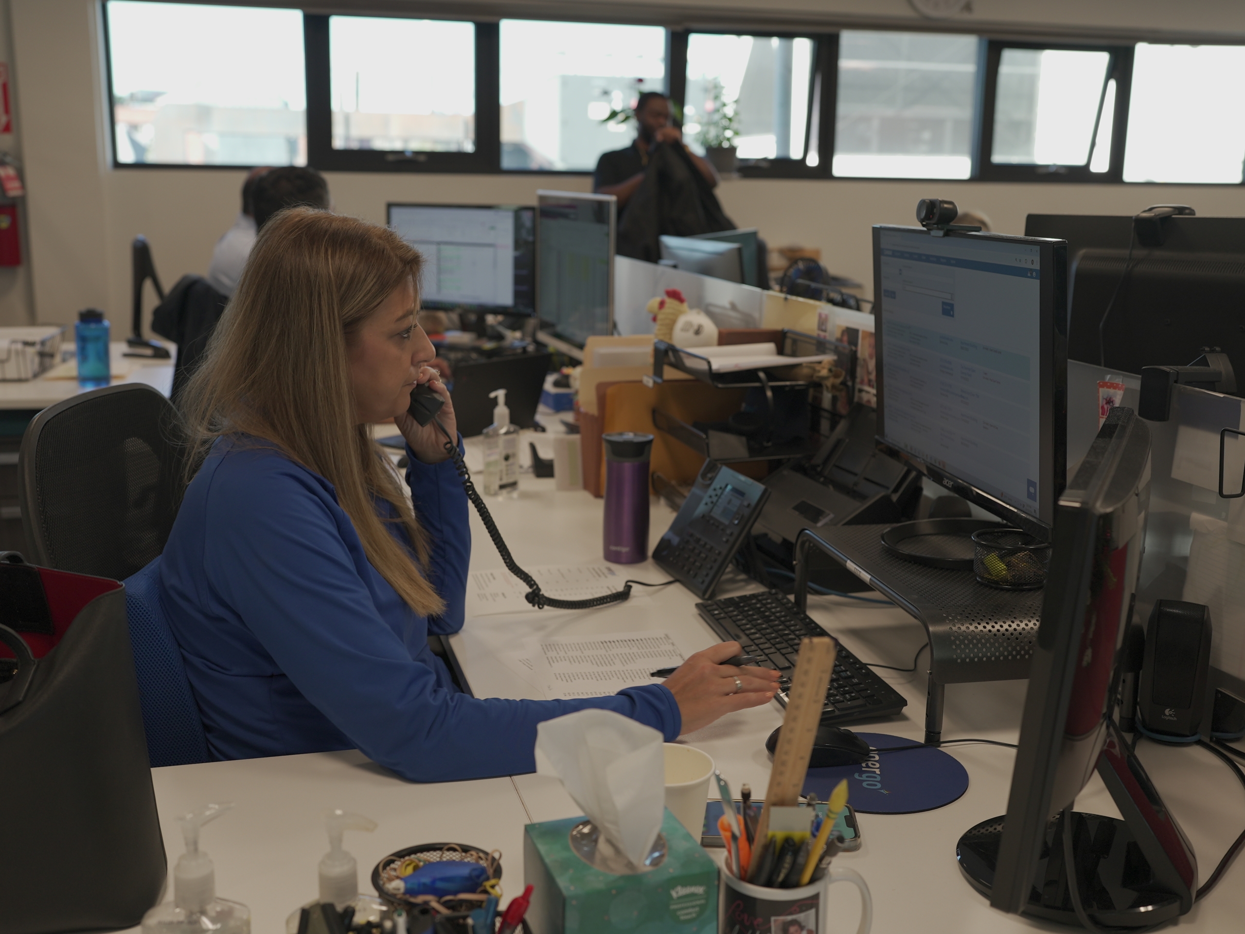 Energo office staff member on phone while working at desk with computer