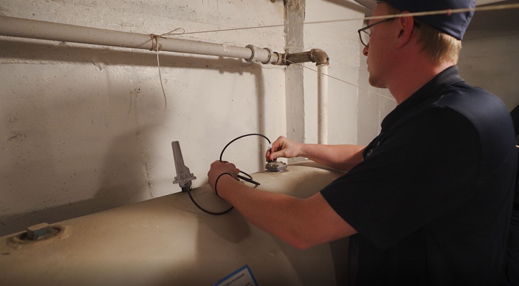Technician inspecting and servicing water heater tank