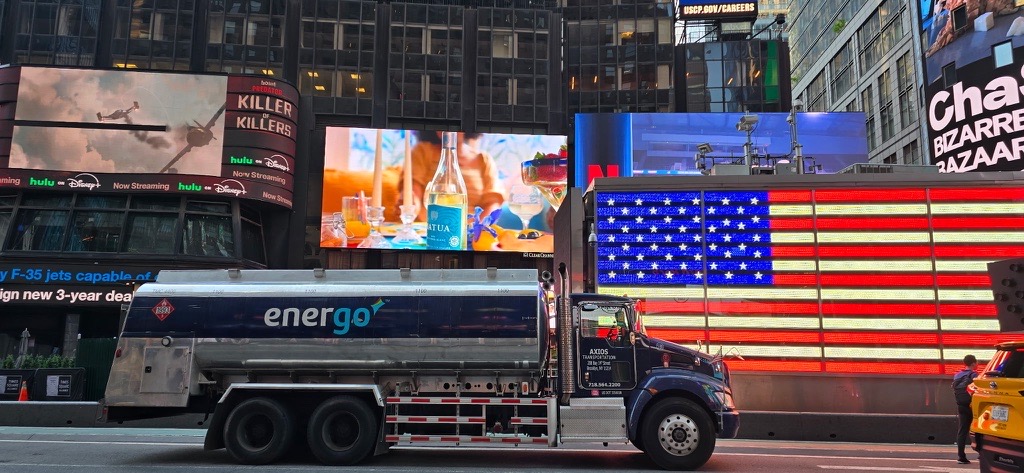 Energo oil delivery truck driving through Times Square with digital billboards