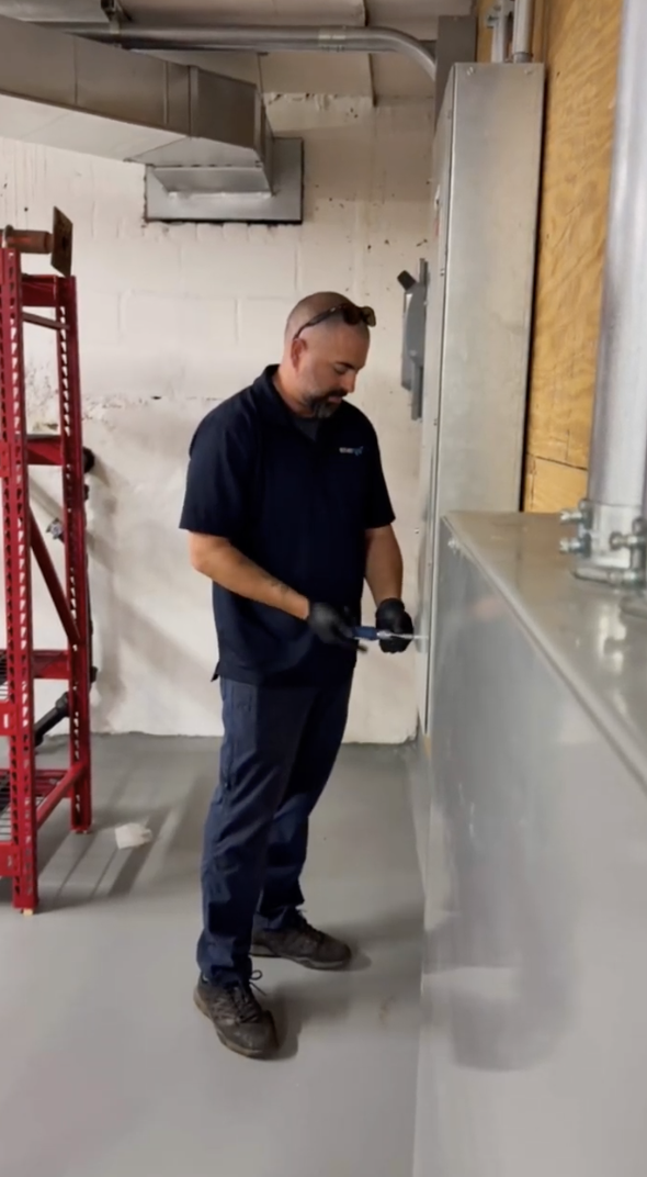 Energo technician inspecting commercial system in utility room