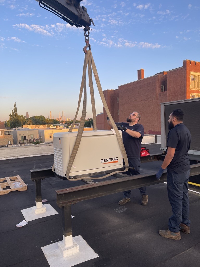 Generac generator being lifted by crane onto rooftop installation